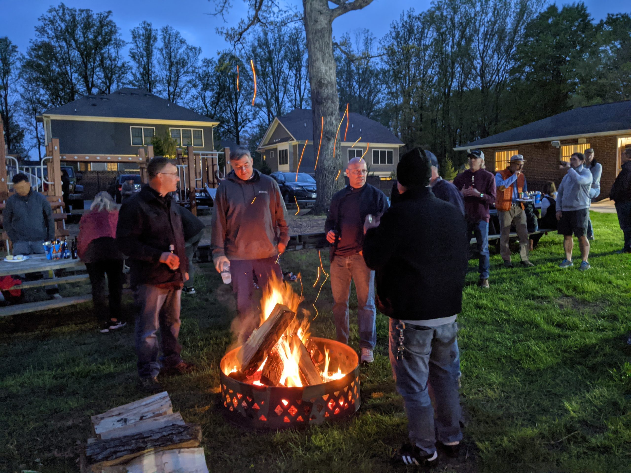 Members gather outside around the fire pit.